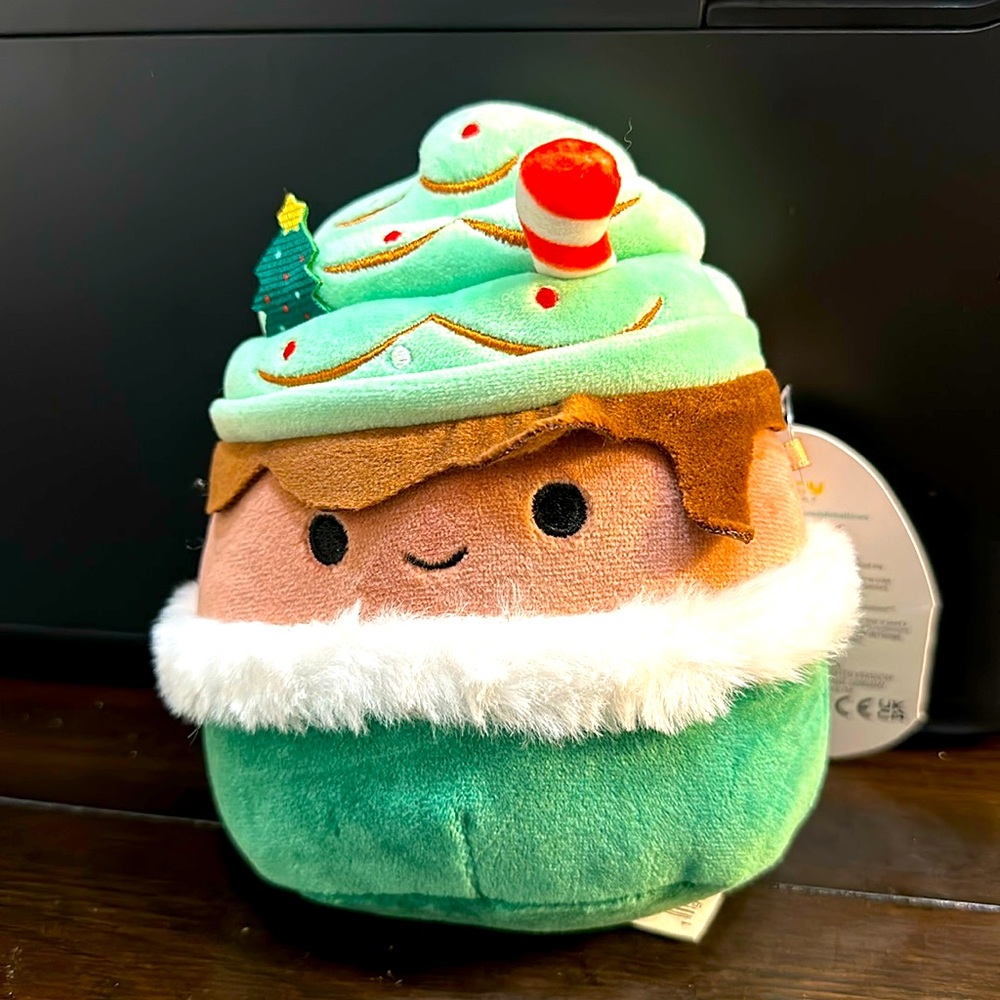 Ernesto Squishmallow is 5 inches tall and wears his green Christmas hat